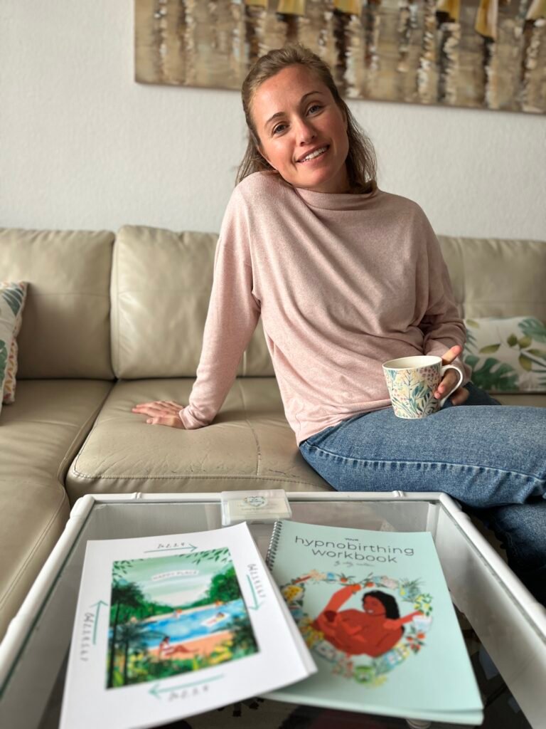 Woman sitting relaxed on couch with healthy snacks and drinks, representing calm pregnancy wellness